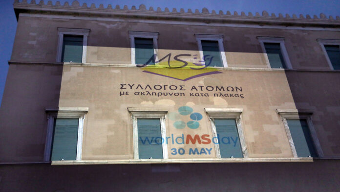 Βουλή: Λαμπερή φωταγώγηση της πρόσοψης με το έμβλημα του Συλλόγου Ατόμων με Σκλήρυνση Κατά Πλάκας