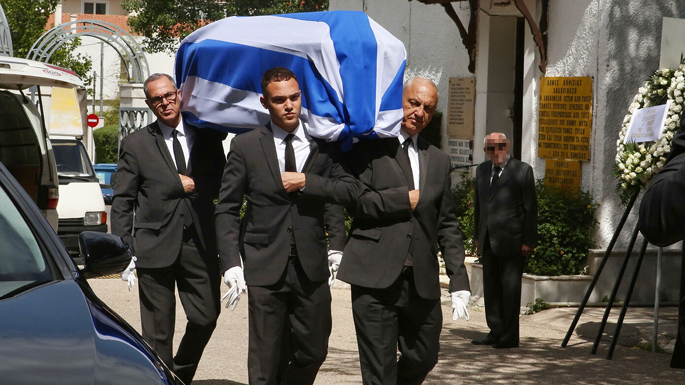 Τυλιγμένη με την ελληνική σημαία έφτασε στην Κηφισιά η σορός του Πέτρου Μολυβιάτη για το τελευταίο αντίο